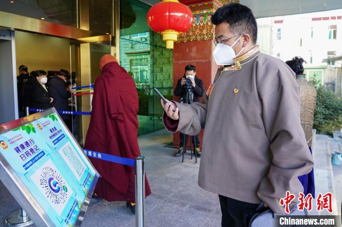 圖為政協委員掃場所碼進入會場。 江飛波 攝