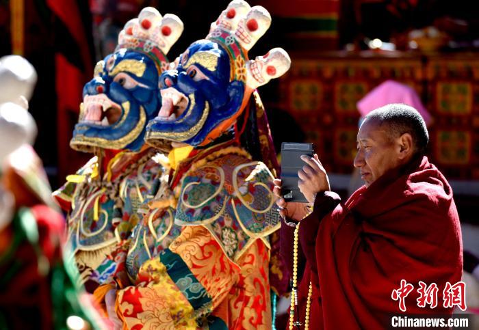 2月19日，正在拍攝跳神活動(dòng)的僧人。　李林 攝