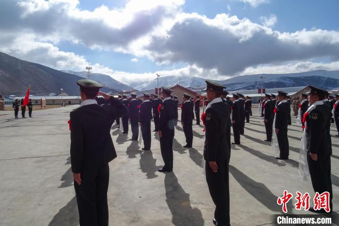 雪山下，退役士兵向軍旗敬軍禮。　李學(xué)文 攝